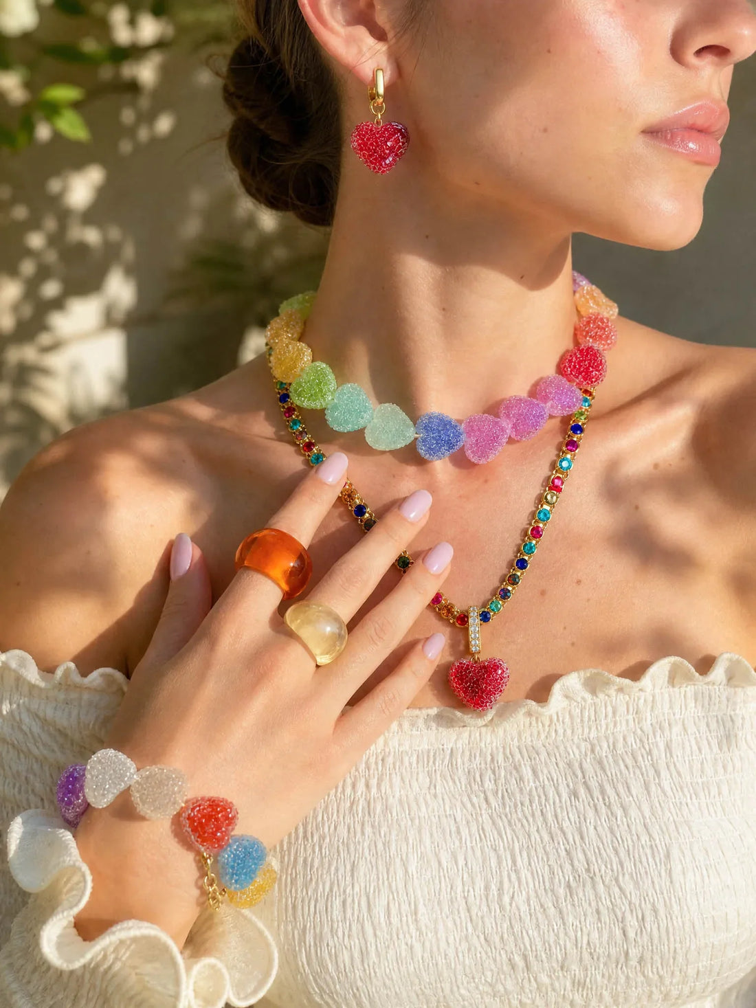 Model styling colorful JellyBlo resin jewelry with a white outfit